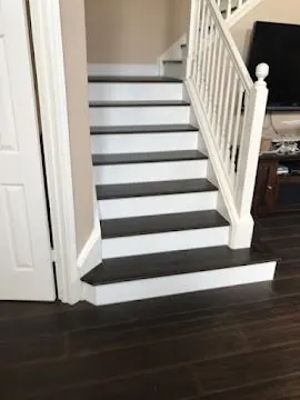 Dark hardwood stair treads with white risers and matching hardwood floor