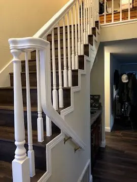 Finished staircase with white painted railing, balusters and hardwood treads